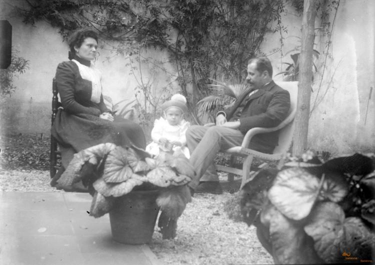 Home, dona i nena amb gorra de cop al badiu o jardí