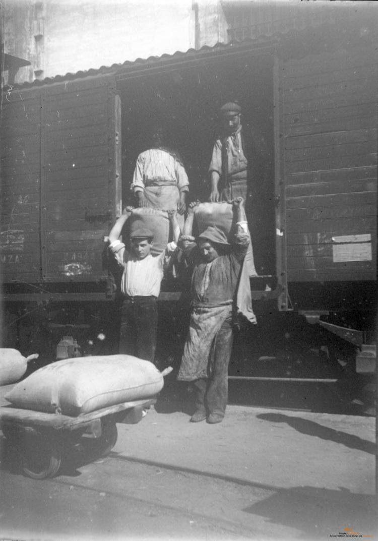 Homes descarregant sacs d'un tren