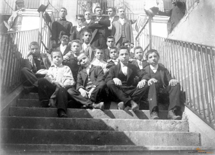 Grup d'homes i nois a una escala, a Can Real (al carrer de la Costa)