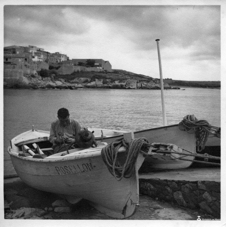 Un pescador sobre la barca varada a la zona de l'Escala (Alt Empordà)