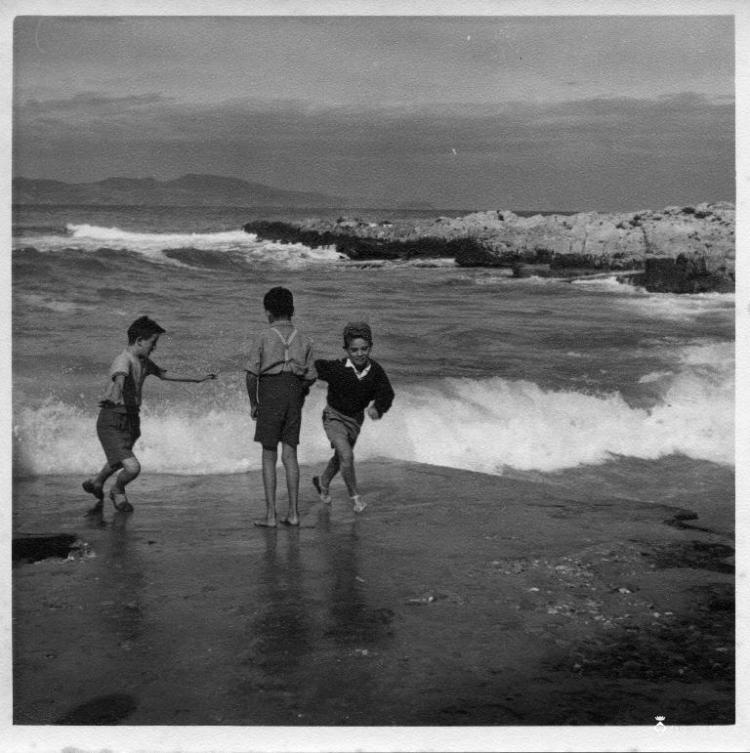 Tres nens jugant a una platja de l'Escala (Alt Empordà)