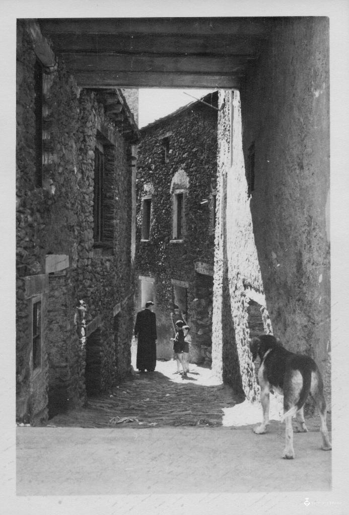Dos nens i un capellà en un carrer d'Ordino, Andorra