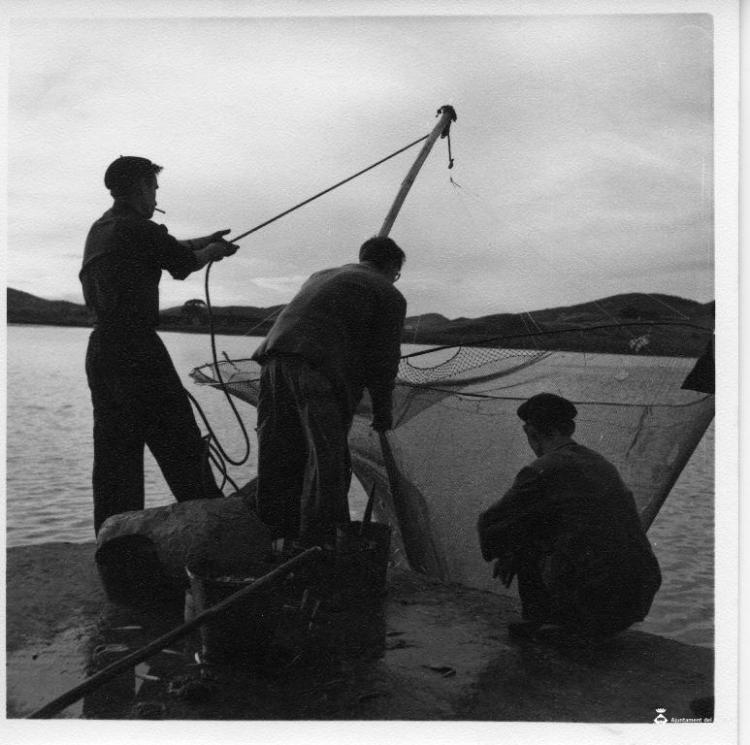 Grup de pescadors estirant una xarxa des del port de Santoña (Cantàbria)