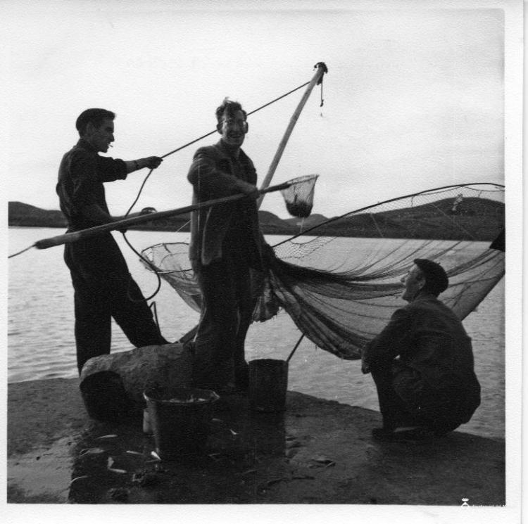 Grup de pescadors estirant una xarxa des del port de Santoña (Cantàbria)