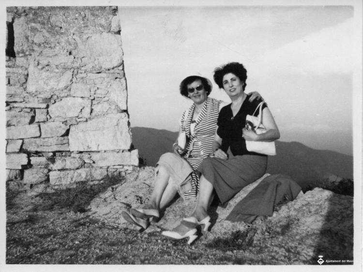 Dues dones assegudes a una roca durant una excursió