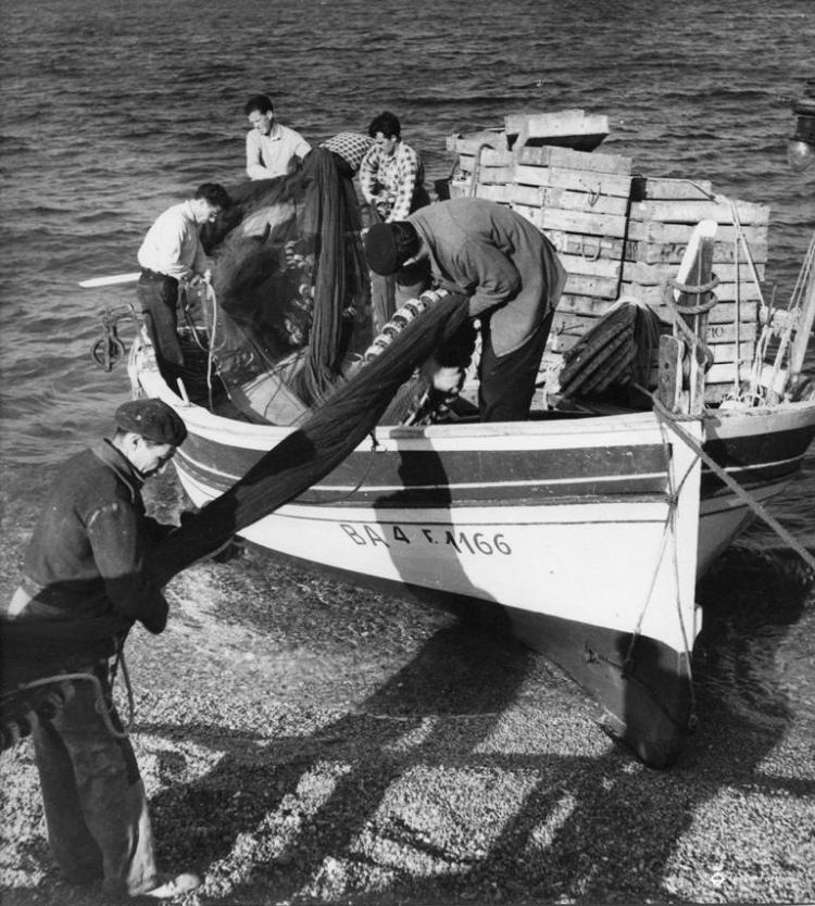 Pescadors descarregant les xarxes des de una barca