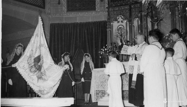 Mossèn Pere Clot beneïnt la bandera de la Sagrada Família el dia de Corpus