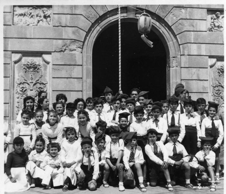 Grup de nens i nenes amb barretina davant l'Ajuntament