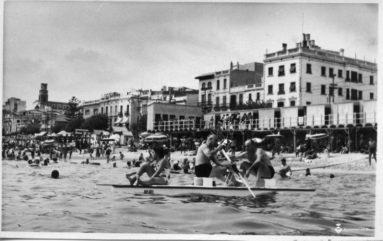 Banyistes remant en un patí davant la platja del Masnou