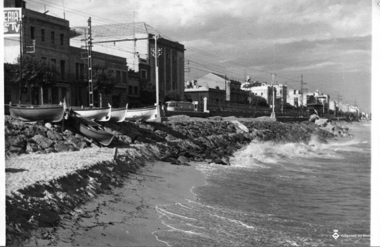 Onades trencant a la platja i les roques de la costa