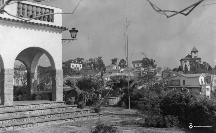 Vista de l'Alberg i altres cases des d'un jardí