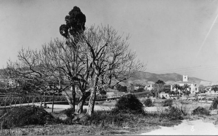 Vista d'uns camps amb una masia al fons