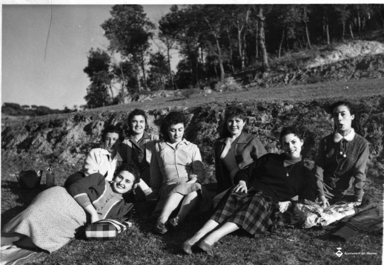 Set alumnes de costura de Teresa Torres assegudes a terra a la zona del Pi de l'Indià