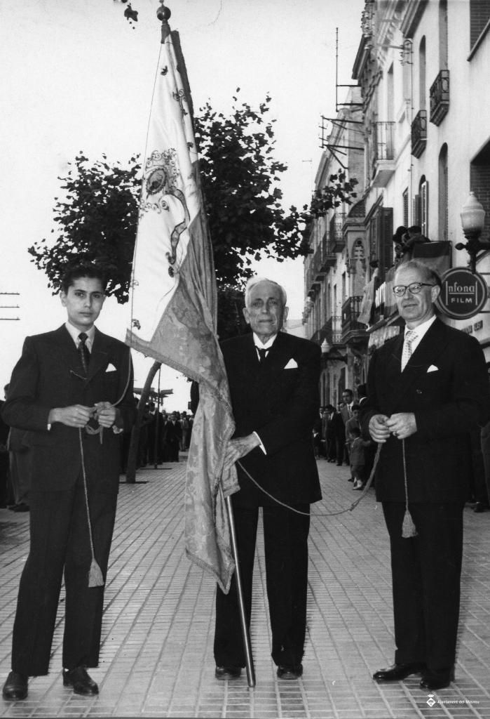 Tres homes amb una bandera durant la processó de Corpus