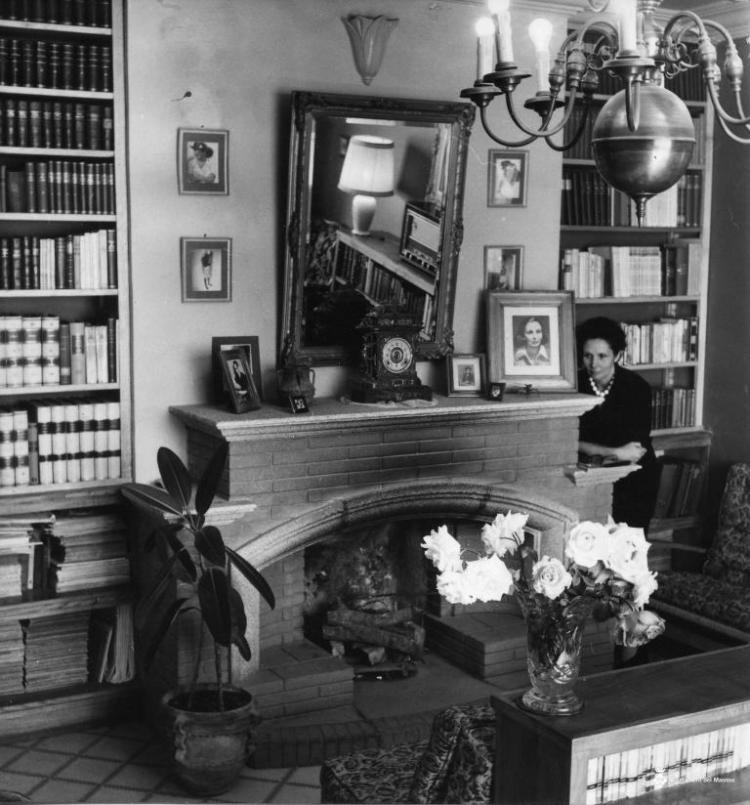 Retrat d'una dona al costat d'una llar de foc a la sala d'estar d'una casa