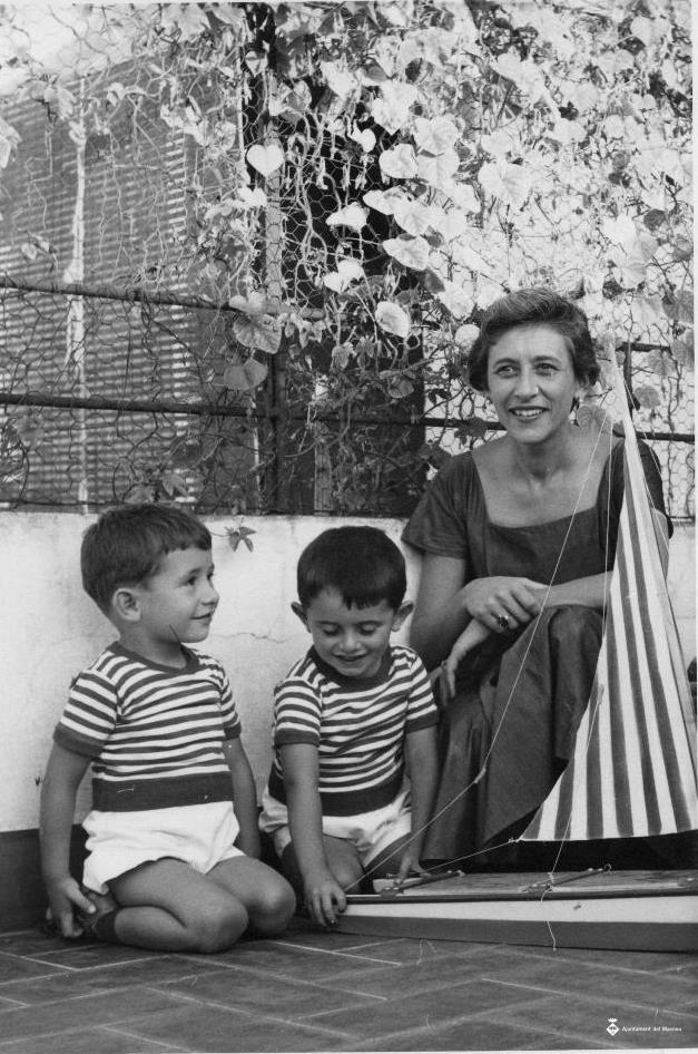Dona amb dos infants jugant amb un vaixell de joguina