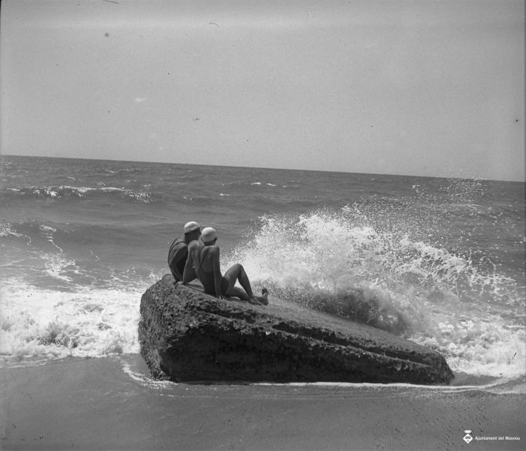 Dos banyistes en una roca a la platja