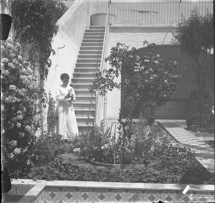 Dona en un jardí en una casa