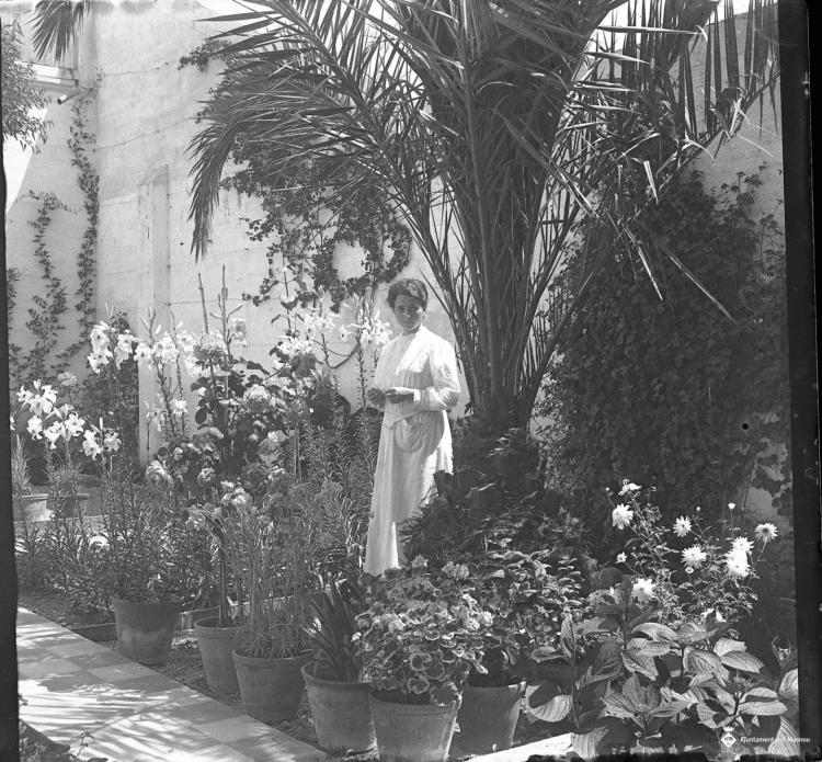 Retrat d'una dona al jardí d'una casa