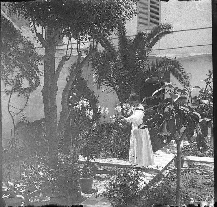 Retrat d'una dona en un jardí d'una casa