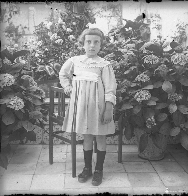 Retrat d'una nena en un jardí particular