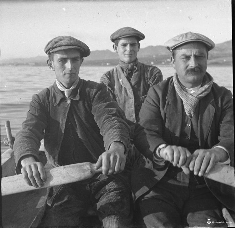 Tres homes en un pati remant cap a la pesca del calamar