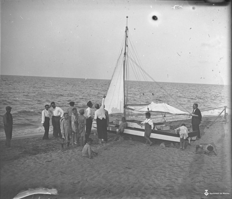 Gent al costat d'un patí a la platja