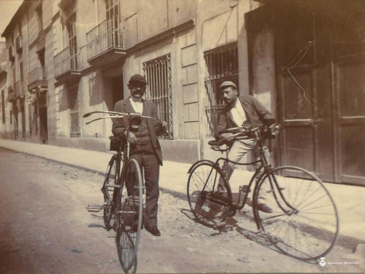 Dos homes amb bicicletes a un carrer de Barcelona