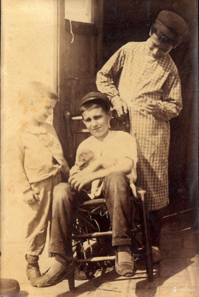Tres nens i un gos davant d'una porta