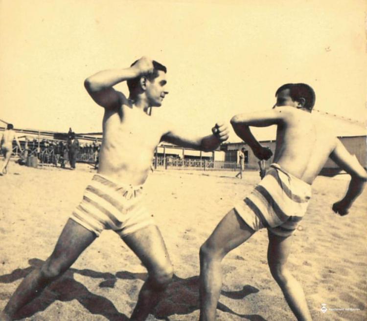 Dos homes jugant a la lluita a la platja