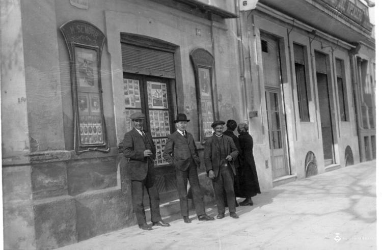 Tres homes davant la botiga de Manuel Sendra
