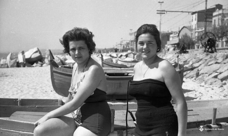 Gent a la platja amb barca