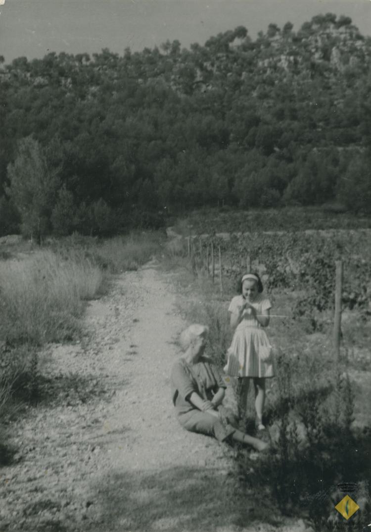 Àvia i nena en un camí entre vinyes