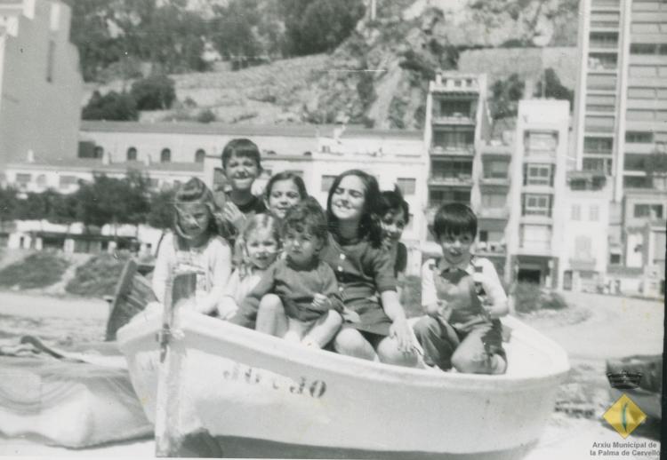 Infants en una barca a la vora del mar