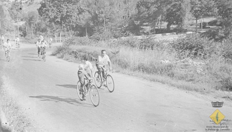 Grup de joves en bicicleta per l'actual carretera BV-2421 el dia de la visita del bisbe de Barcelona