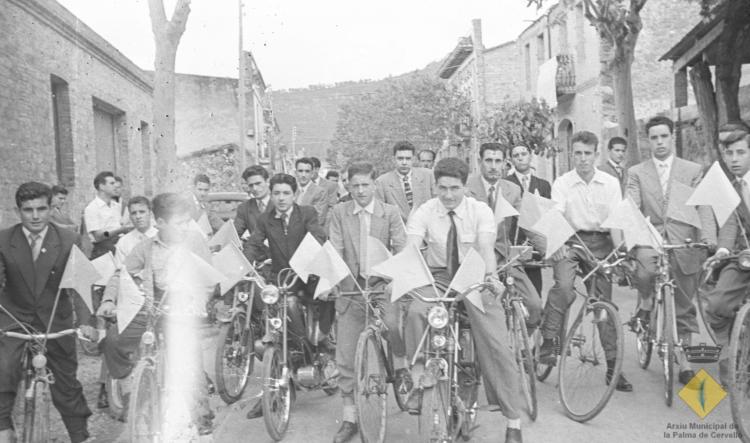 Grup de joves en bicicleta i amb banderins per anar a rebre el bisbe de Barcelona, el Dr. Jubany