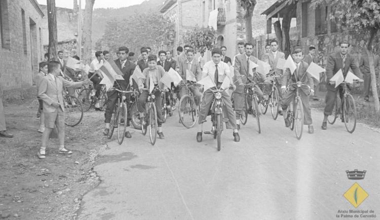 Grup de joves en bicicleta i amb banderins per anar a rebre el bisbe de Barcelona, el Dr. Jubany