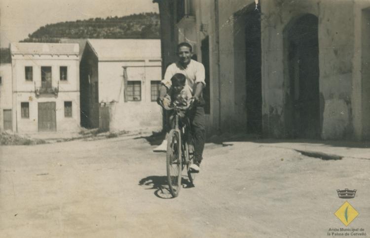 Miquel Aguilar amb el seu fill Àngel Aguilar en una bicicleta al carrer Santa Maria