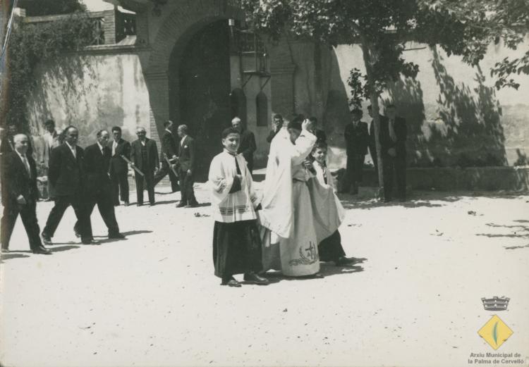 Mossèn i dos escolanets a la plaça de l'església