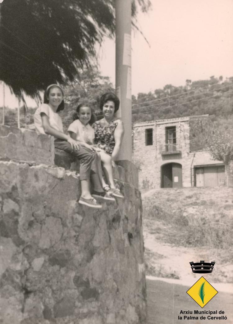 Mare i fills fotografiats a la terrassa de l'Aliança Palmarenca, amb la casa del número 104 de l'avinguda Catalunya al darrera
