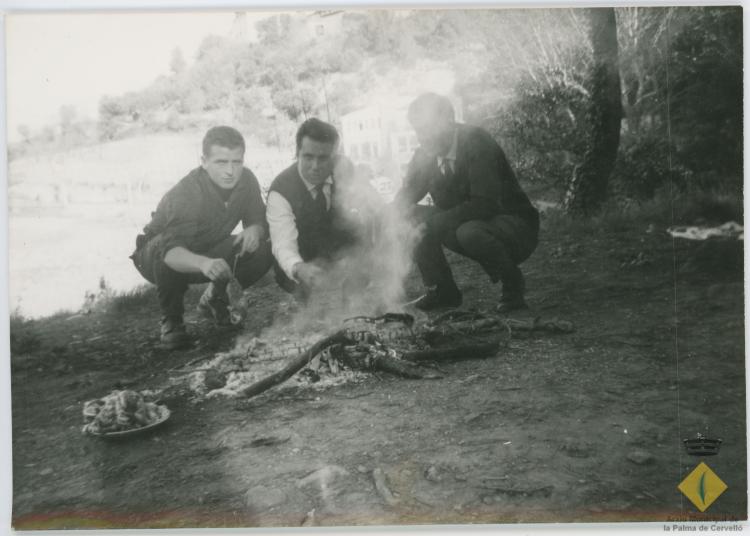 Grup d'amics d'excursió, amb una foguera per fer carn a la brasa