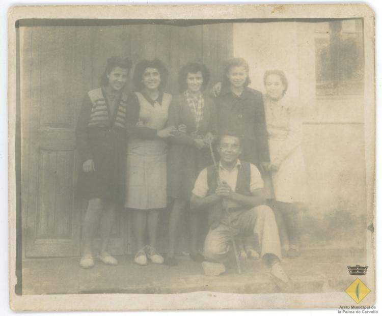Retrat d'un grup de joves davant la porta de l'escola
