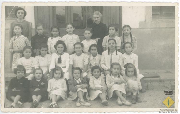 Retrat del grup escolar de nenes davant la porta de l'escola