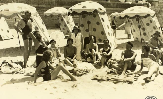 Grup d'homes i dones a la platja. França (?)