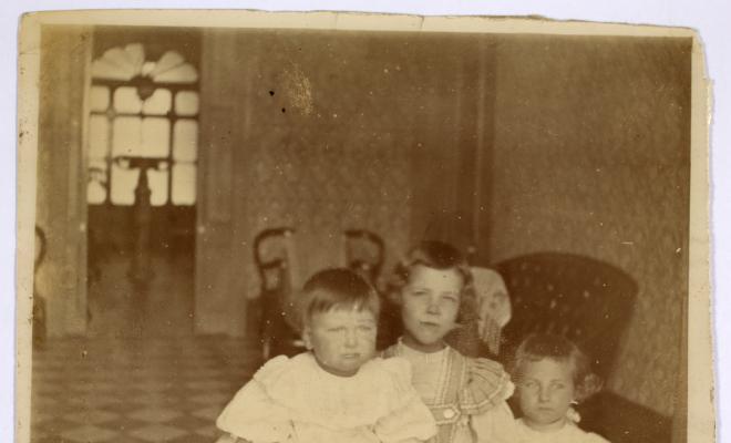 Tres infants a l'interior d'una casa. S.l.