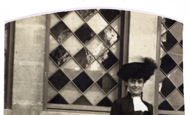 Dona darrera d'una tanca de fusta. S.l.