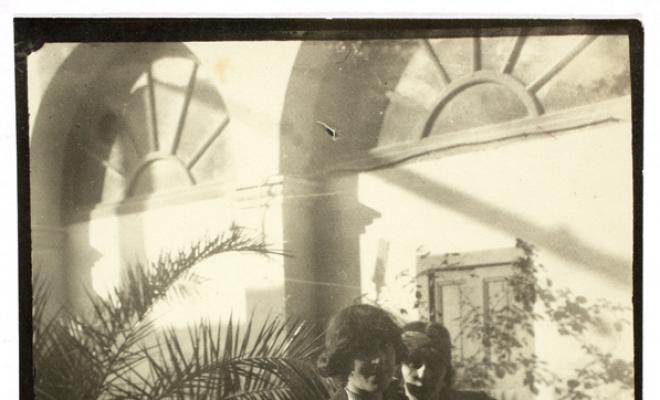 Dues dones al voltant d'una taula rodona en un jardí. S.l.