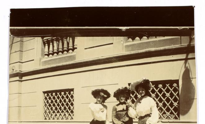 Tres dones davant la façana d'un edifici. S.l.