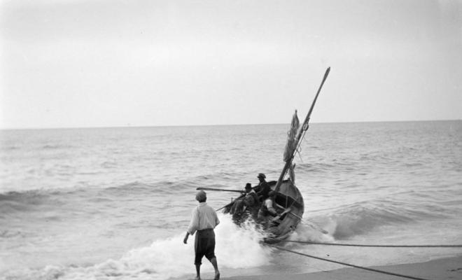 Arribada d'una barca a una platja de Caldes d'Estrac