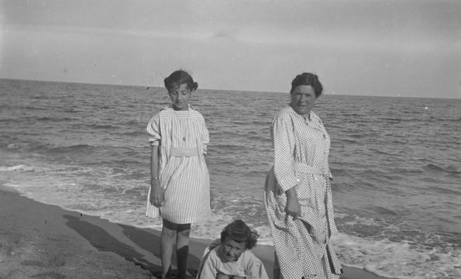 Dues nenes i una dona en una platja a Caldes d'Estrac